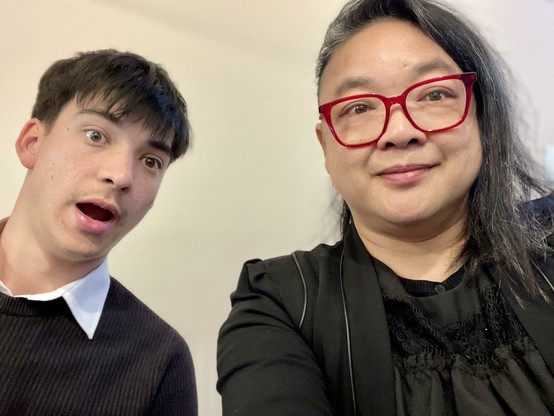A young man and a woman looking at the camera. The young man looks very surprised. The woman wears red glasses. Both are mostly Asian 🥰