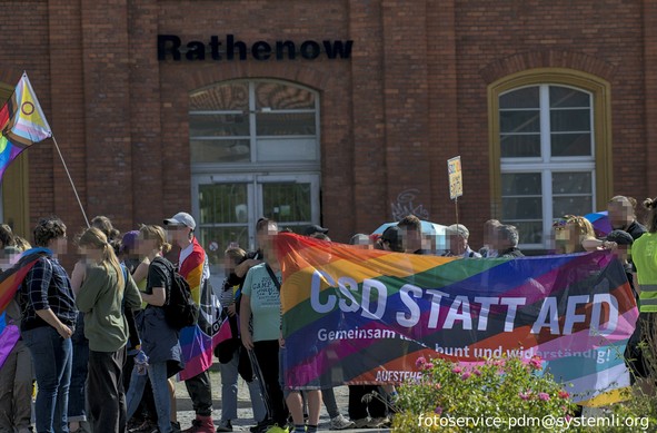 vor dem bahnhof rathenow beginnt die csd parade. davro ein banner "csd statt afd"