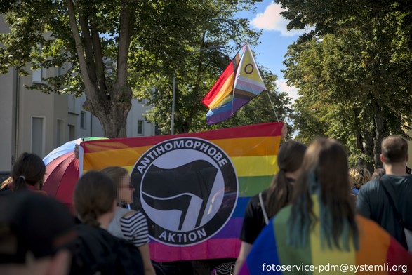 demozug, eine regenbogenflagge mit "antihomophobe aktion" in der bildmitte