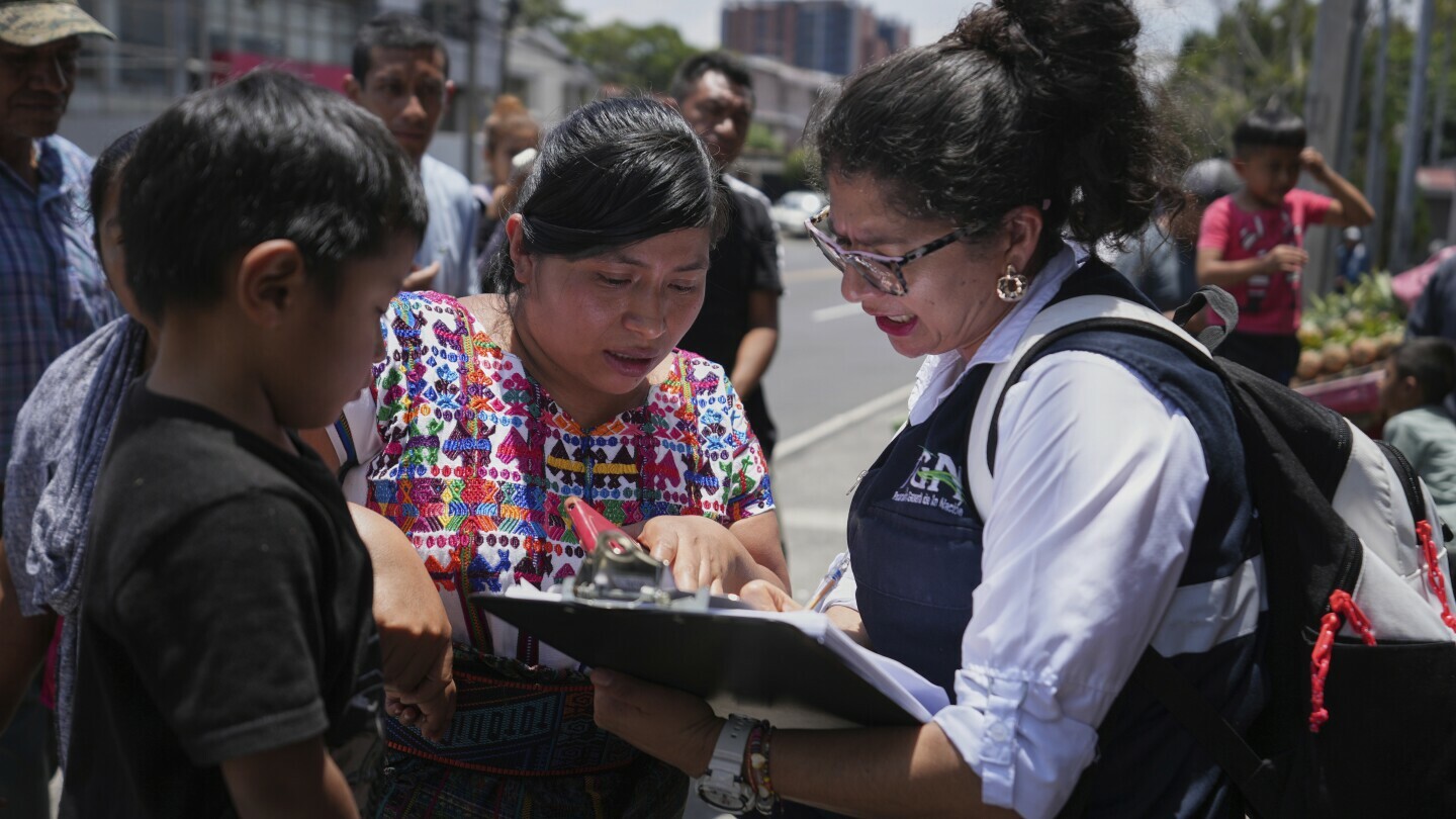 A relative of an unaccompanied minor deported from the United States reviews the list of those deported outside La Aurora International Airport, in Guatemala City, Sunday, Aug. 31, 2025. (AP Photo/Moises Castillo)